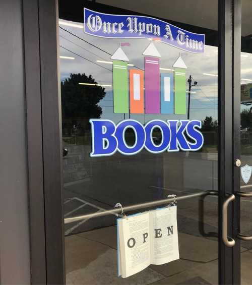 A storefront with a colorful "Books" sign and an "Open" sign hanging from the door.