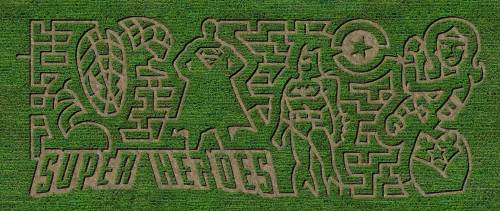 Aerial view of a corn maze featuring superhero silhouettes and the text "Super Heroes" carved into the greenery.