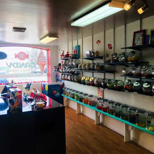 A colorful candy shop interior with shelves filled with jars of various candies and a bright window display.