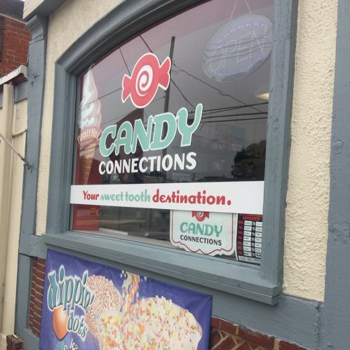 Storefront window of "Candy Connections" with colorful signage promoting it as a sweet tooth destination.