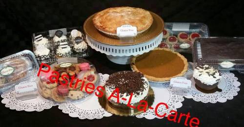 A variety of desserts displayed on a table, including cakes, pies, and cupcakes, with a label reading "Pastries A La Carte."
