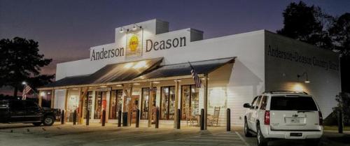 A well-lit storefront of Anderson Deason at dusk, featuring large windows and a welcoming entrance.
