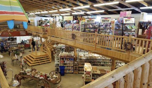 A spacious store interior with wooden decor, multiple levels, and various products displayed on shelves and tables.