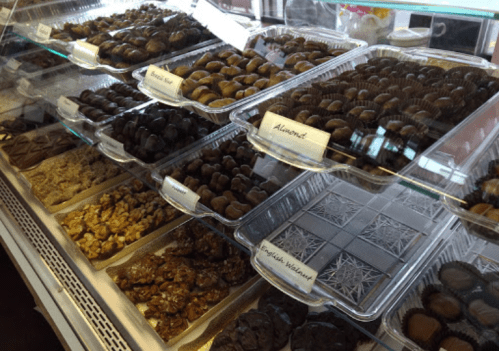 A display case filled with various chocolate confections, including almond and English walnut treats.