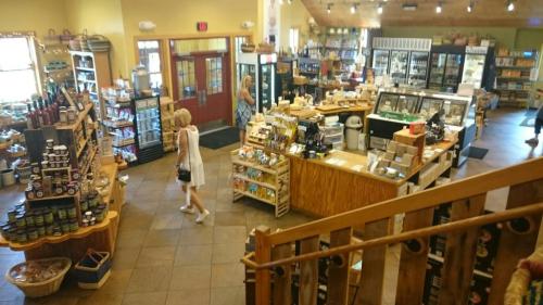 A spacious store filled with shelves of products, featuring customers browsing and a warm, inviting atmosphere.