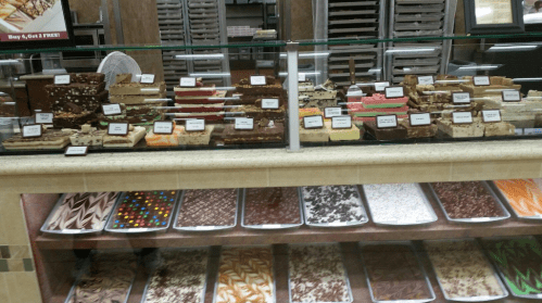 A display case filled with various types of fudge and confections, labeled with prices and flavors.