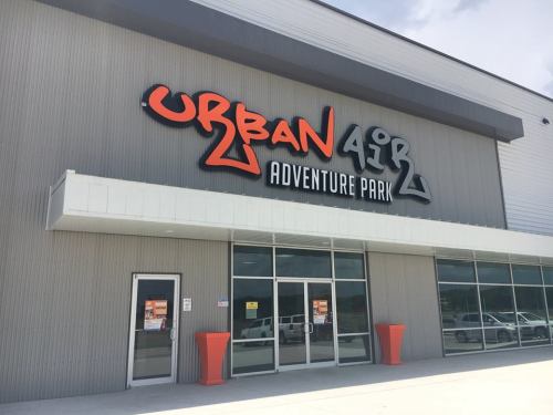 Exterior of Urban Air Adventure Park, featuring a large sign and entrance with orange and gray colors.