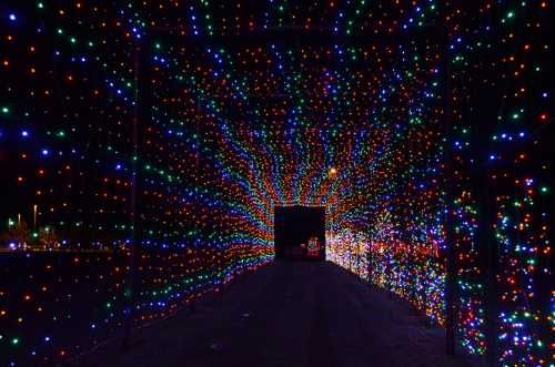 A colorful tunnel of lights in red, green, and blue, creating a vibrant, festive atmosphere.