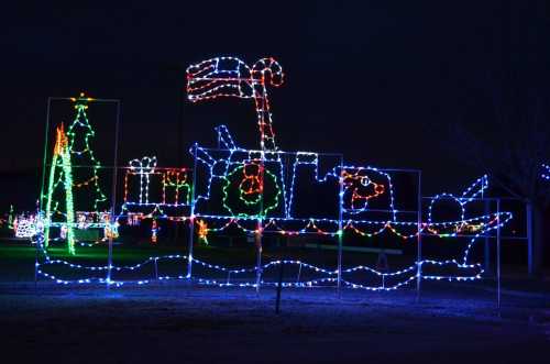 Colorful holiday lights depict a boat with a flag, surrounded by festive decorations like a Christmas tree.