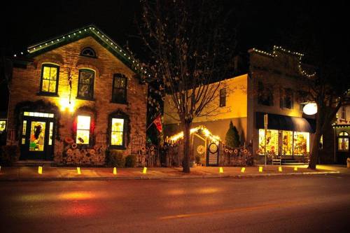 Charming buildings adorned with festive lights at night, creating a warm, inviting atmosphere on a quiet street.