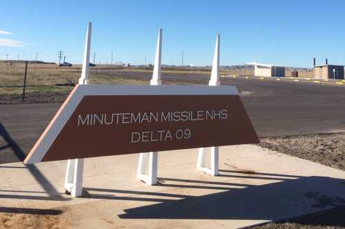 Sign for Minuteman Missile National Historic Site, Delta 09, with a clear blue sky in the background.