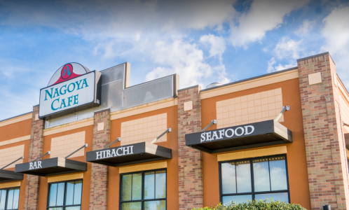Exterior of Nagoya Cafe featuring signs for Bar, Hibachi, and Seafood against a blue sky.