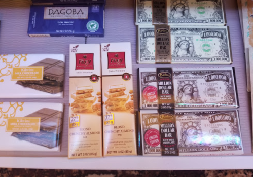 A display of chocolate bars and novelty money, including a "Million Dollar Bar" and various candy boxes.