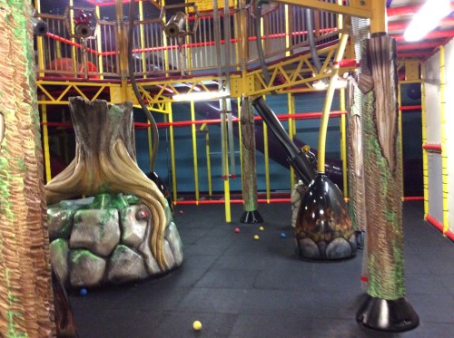 Indoor playground featuring colorful structures, climbing elements, and soft flooring for children to play on.