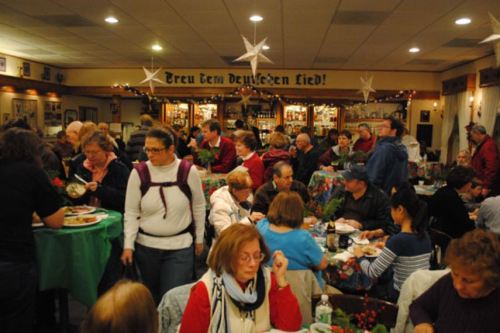 A bustling dining room filled with people enjoying a meal, decorated for a festive occasion.
