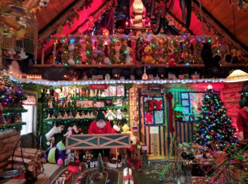 A festive room decorated with colorful lights, a Christmas tree, toys, and holiday decorations, creating a cheerful atmosphere.