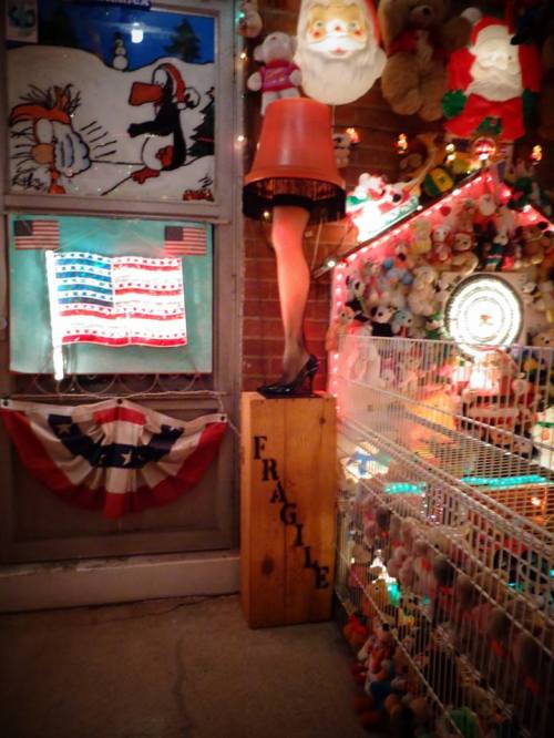 A whimsical display featuring a leg lamp, stuffed animals, and festive decorations in a cozy setting.
