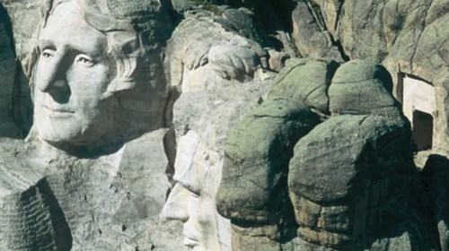 Mount Rushmore featuring the carved faces of four U.S. presidents on a rocky mountain backdrop.