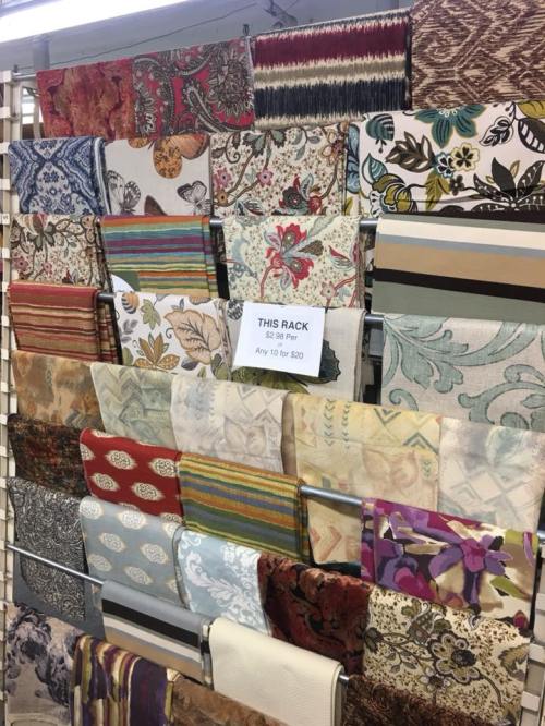 A display rack filled with various colorful fabric samples, showcasing different patterns and textures.