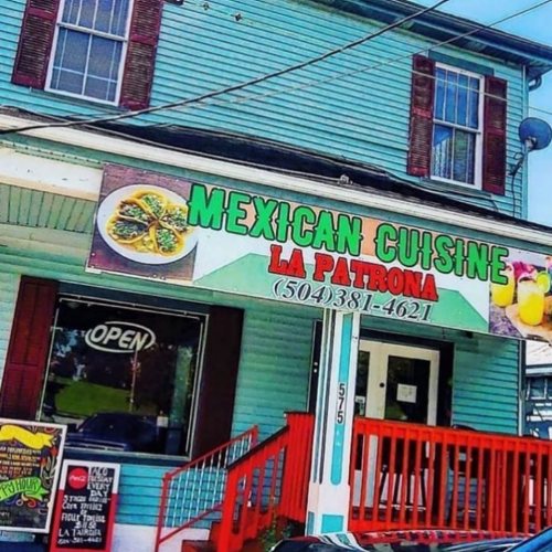 Colorful exterior of La Patrona restaurant featuring a sign for Mexican cuisine and an open sign in the window.