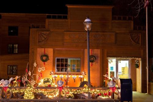 A warmly lit building decorated with holiday lights and wreaths, featuring cowboy hats and festive ornaments.