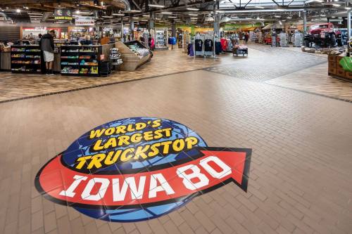 Interior of the World's Largest Truckstop, Iowa 80, featuring merchandise displays and a large logo on the floor.