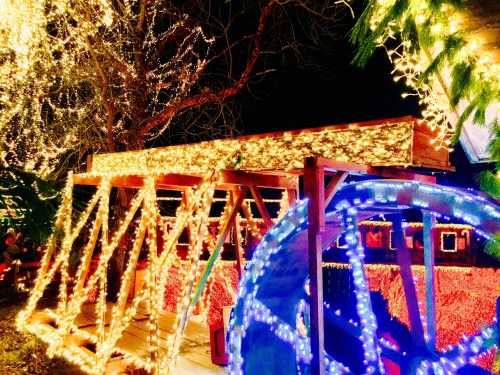 A brightly lit wooden structure adorned with colorful holiday lights, surrounded by festive decorations at night.