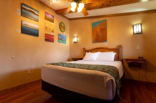 Cozy bedroom with a wooden bed, colorful wall art, and warm lighting.