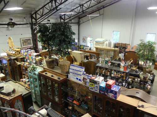 A spacious antique shop filled with various vintage items, furniture, and decorative pieces arranged on shelves and tables.