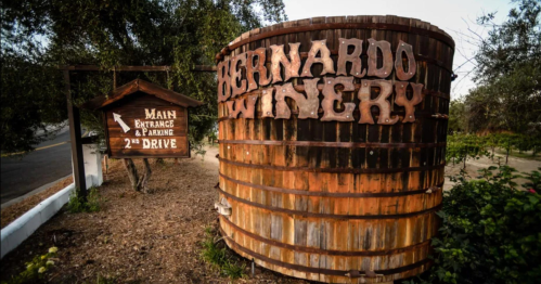 Sign for Bernardo Winery featuring a large wooden barrel and a smaller sign indicating the main entrance and parking.