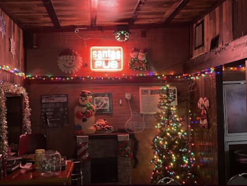 Cozy pub interior decorated for the holidays, featuring a Christmas tree, lights, and festive ornaments.