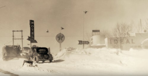 A vintage scene of a snowy roadside with a car, motel signs, and snowdrifts, evoking a nostalgic winter atmosphere.