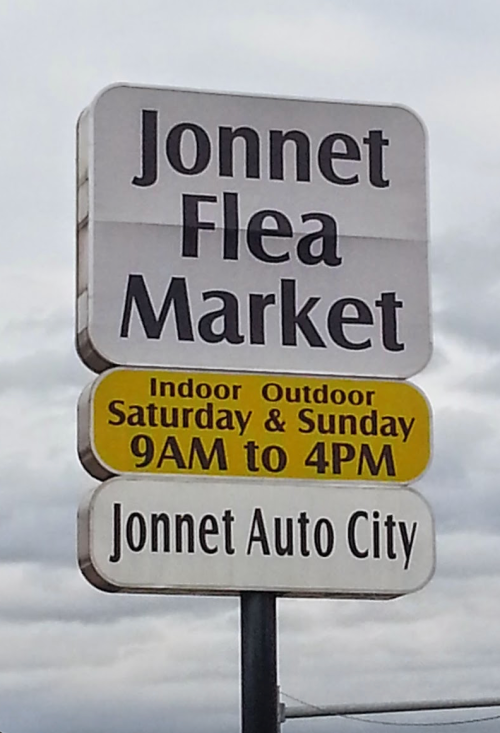 Sign for Jonnet Flea Market, open Saturday and Sunday from 9 AM to 4 PM, located at Jonnet Auto City.