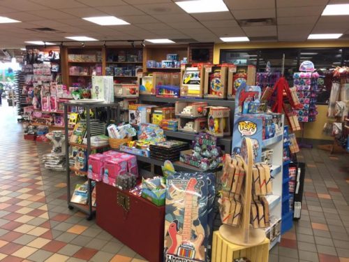A colorful toy store display featuring various toys, games, and merchandise on shelves and tables.