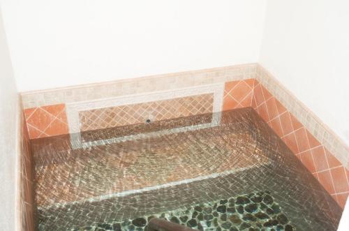A serene indoor pool with clear water and a tiled border, featuring smooth pebbles at the bottom.