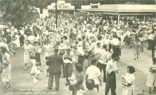A busy amusement park midway with crowds of people enjoying the attractions at Lake Compounce, Bristol, Connecticut.