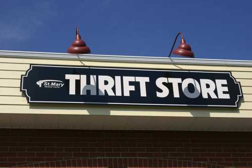 Sign for "THRIFT STORE" on a building with a blue sky in the background.