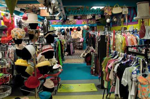 A colorful vintage clothing store filled with racks of hats and clothing in a vibrant, eclectic setting.