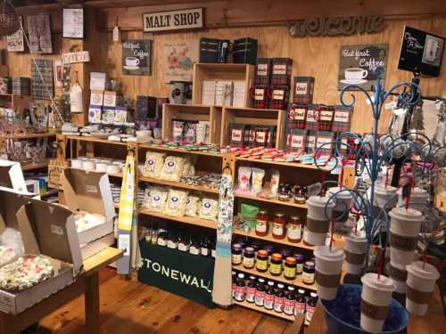 A cozy shop interior filled with shelves of various goods, including coffee, jams, and decorative items.