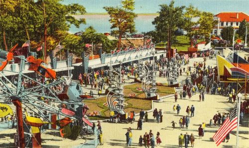 A vibrant vintage postcard depicting a busy amusement park with a ferris wheel, flags, and crowds enjoying the day.