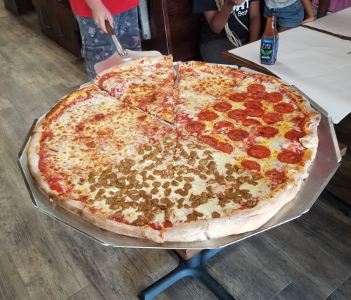 A large pizza with four sections: cheese, pepperoni, and a unique topping of cereal on one quarter.