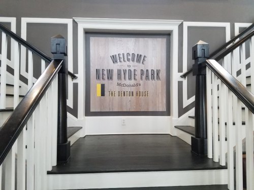 Staircase leading to a sign that reads "Welcome to New Hyde Park McDonald's The Denton House."