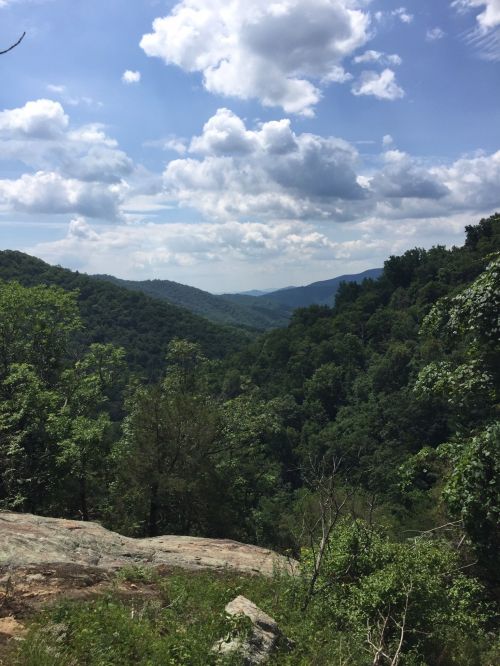 A scenic view of lush green mountains under a partly cloudy sky.