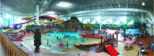 A vibrant indoor water park featuring slides, a wave pool, and families enjoying various water activities.