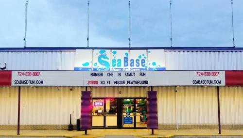 Exterior of SeaBase, a family fun center, featuring a large sign and an indoor playground.