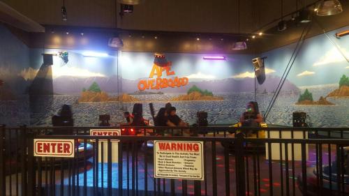 A colorful indoor amusement area with bumper cars and a scenic mural of mountains and water in the background.