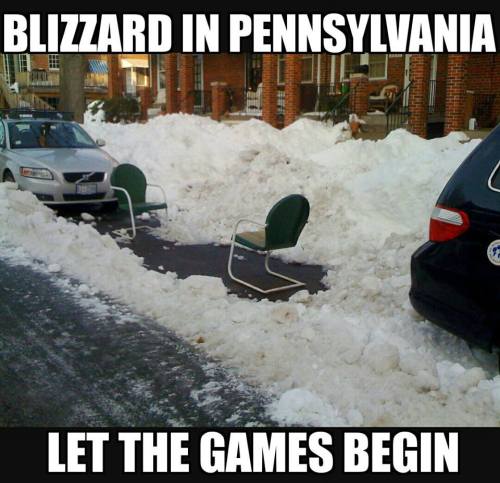 A snowy street in Pennsylvania with two chairs on a cleared path, surrounded by large snow piles. Text: "Blizzard in Pennsylvania. Let the games begin."