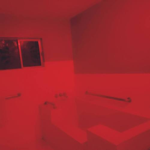 A dimly lit bathroom with red lighting, featuring a bathtub, sink, and window.