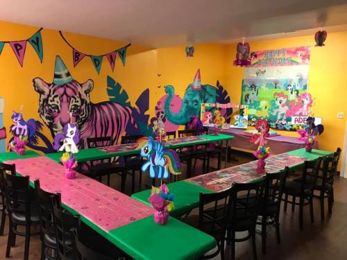 Colorful birthday party setup with pony decorations, vibrant walls, and festive table settings.
