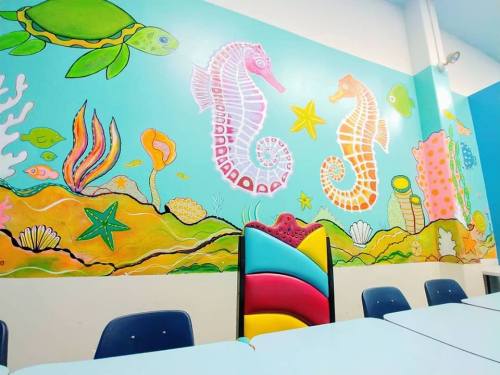 Colorful underwater-themed mural featuring seahorses, turtles, and coral, with a vibrant chair in the foreground.